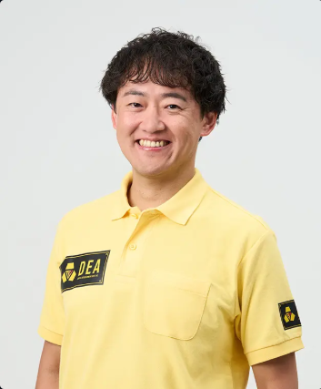 DEAロゴの黄色いシャツを着た人物