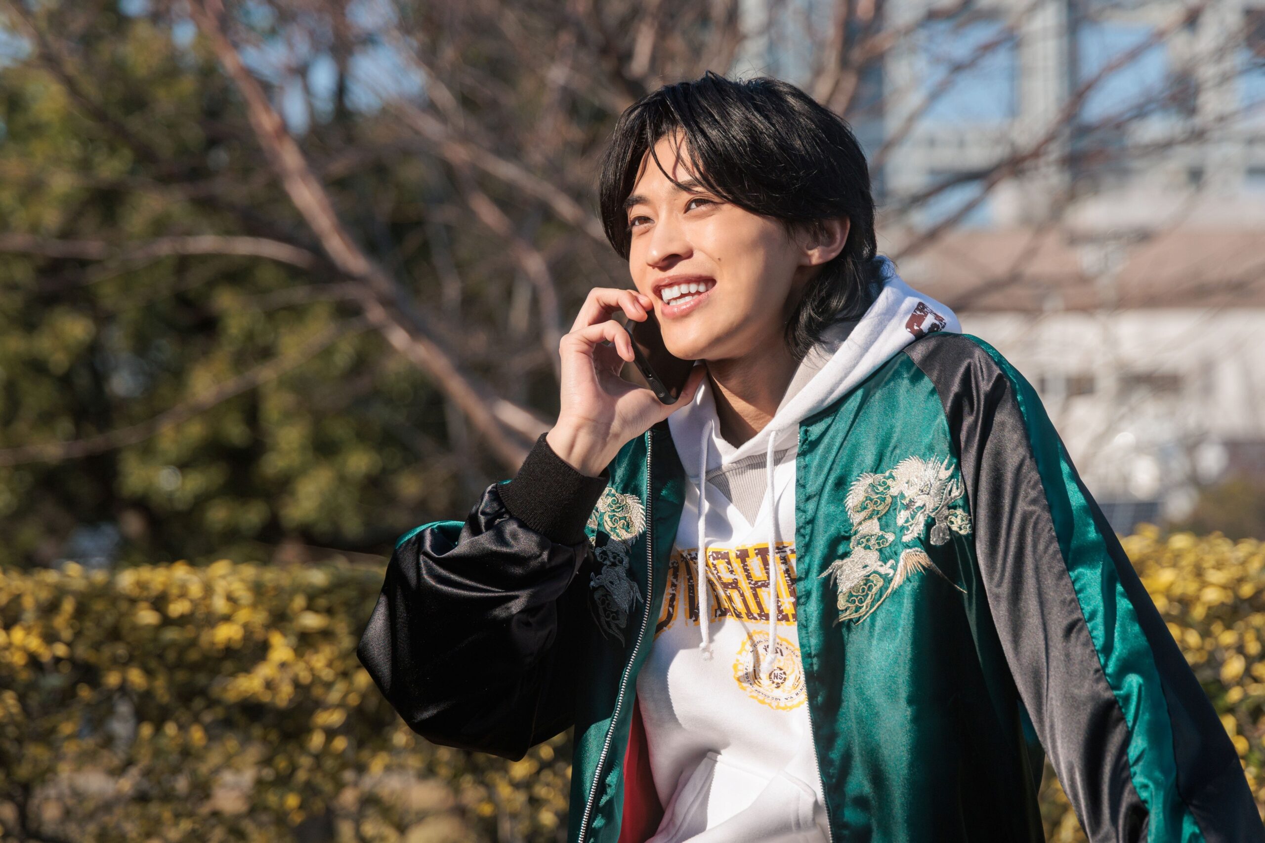 外で電話をして笑顔の男性