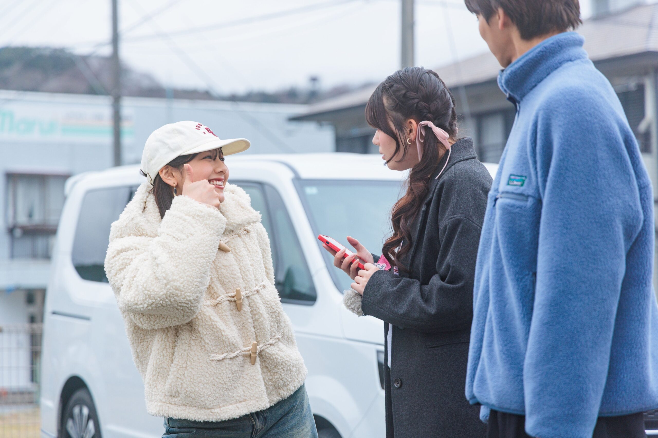 車の前で話す女性たちと男性