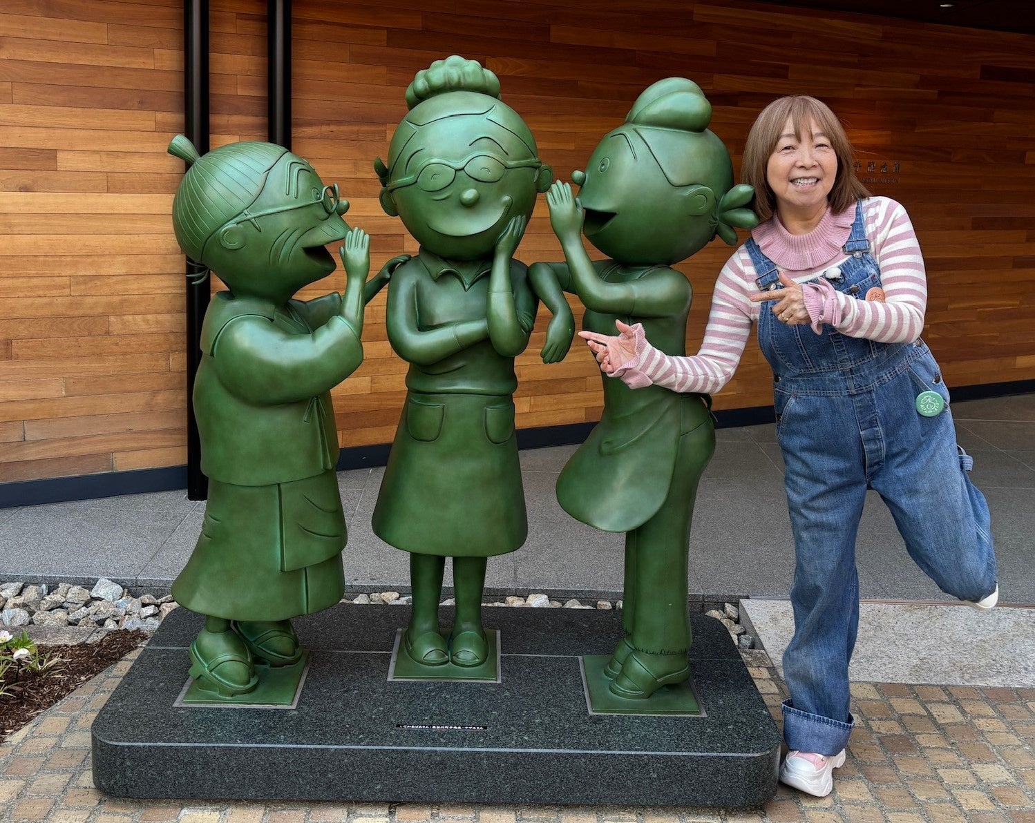 漫画キャラの彫刻と女性がポーズ