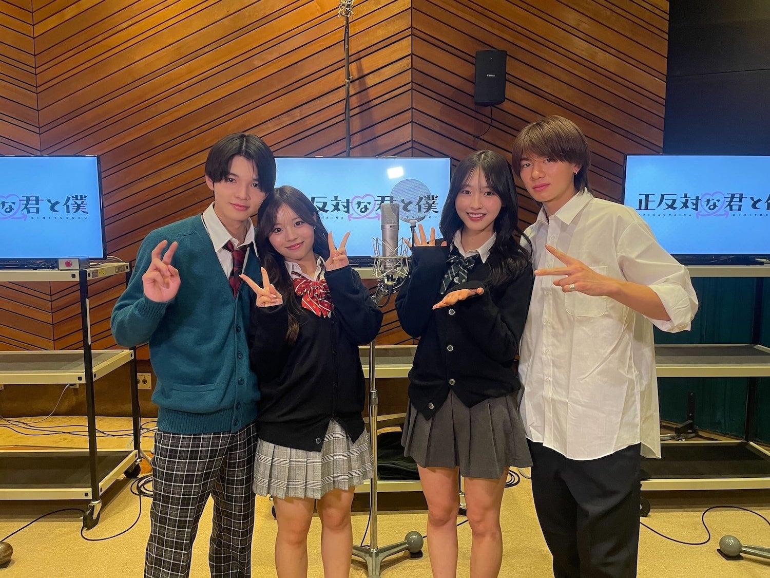 制服姿の男女4人がポーズ