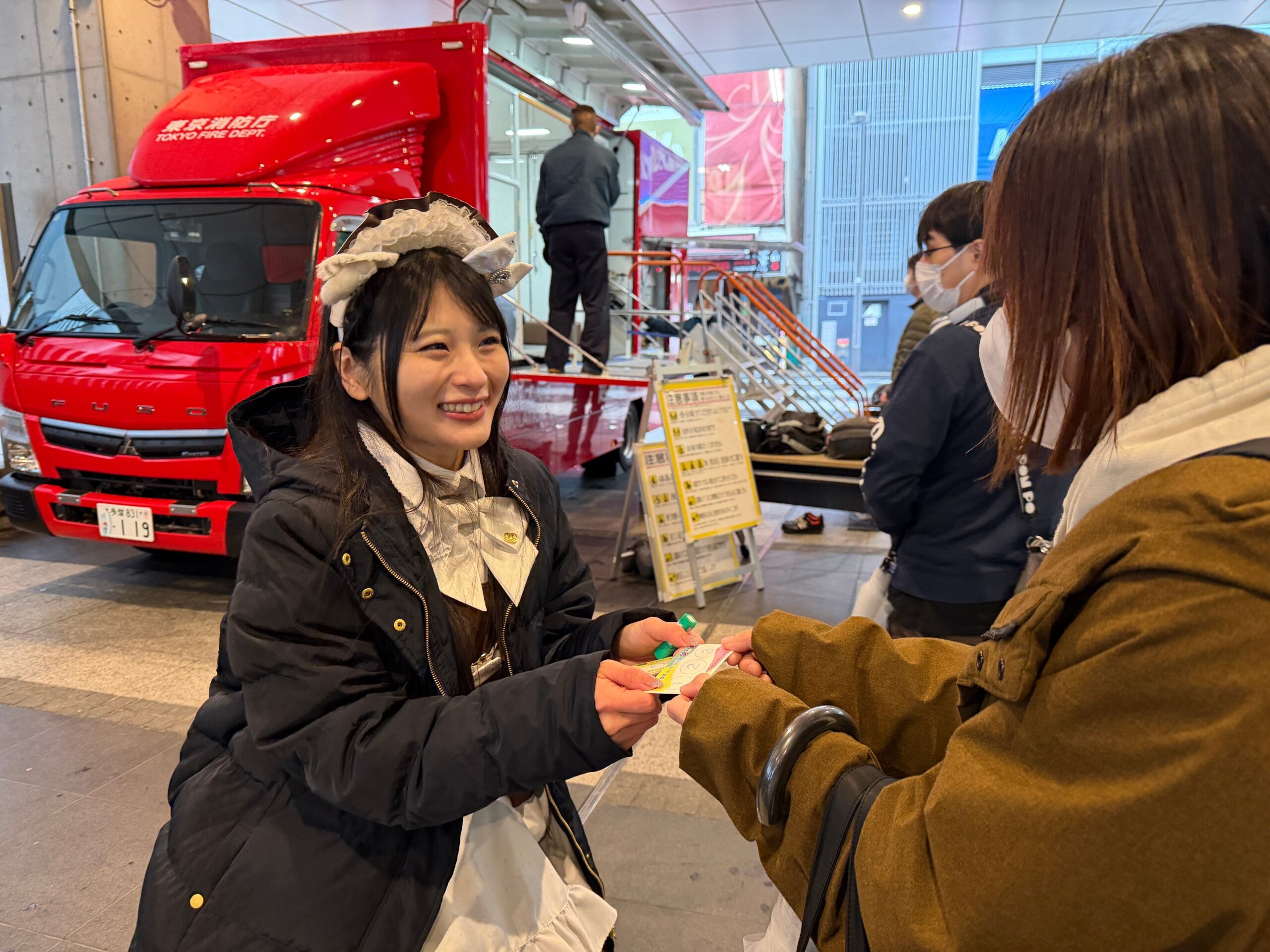 笑顔のメイドが防災活動で名刺を配布