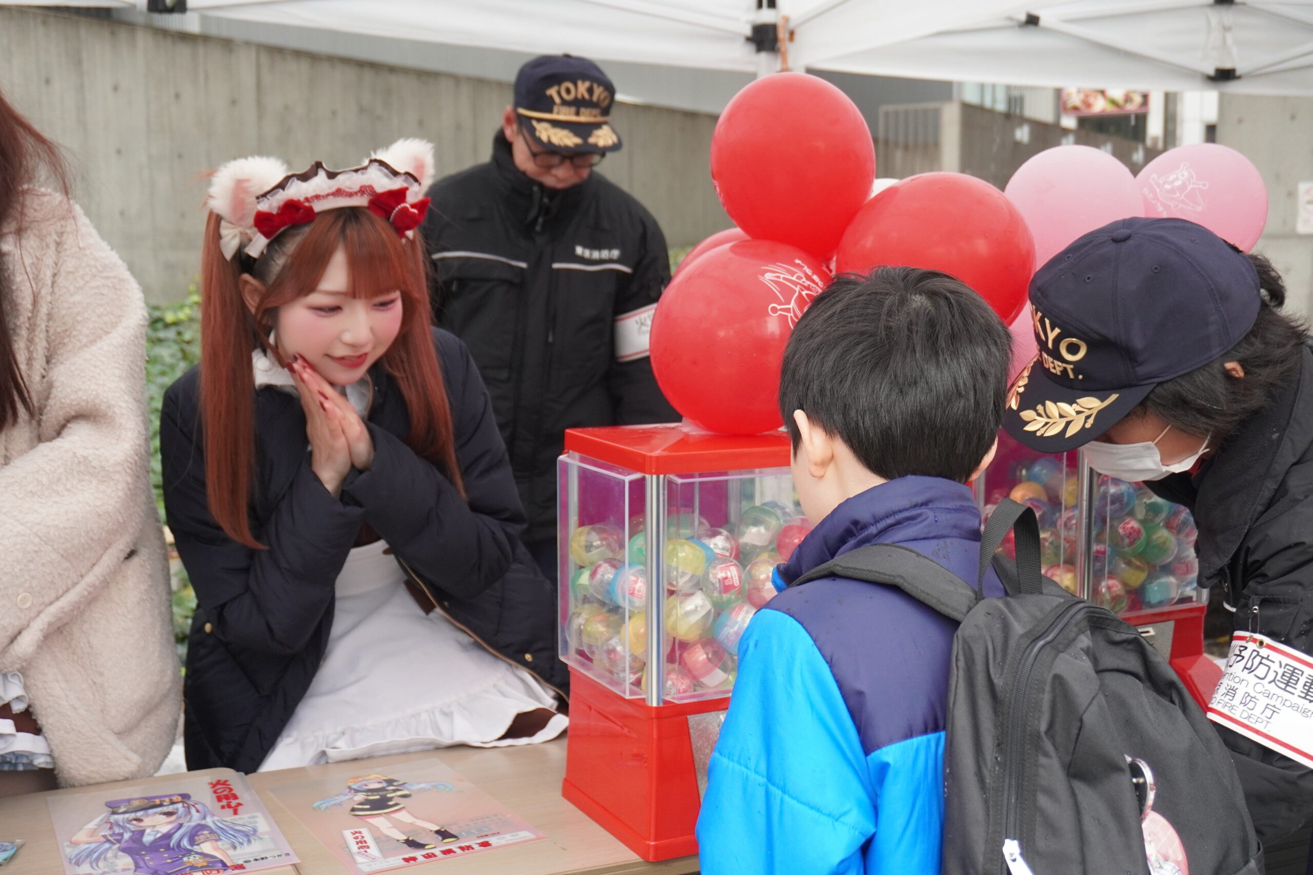 メイドが防災活動で配布物を手渡し
