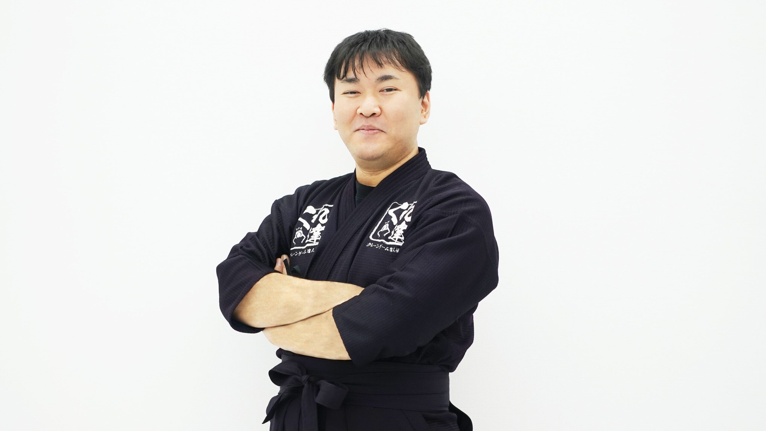 腕を組むクレーンゲームのプロ