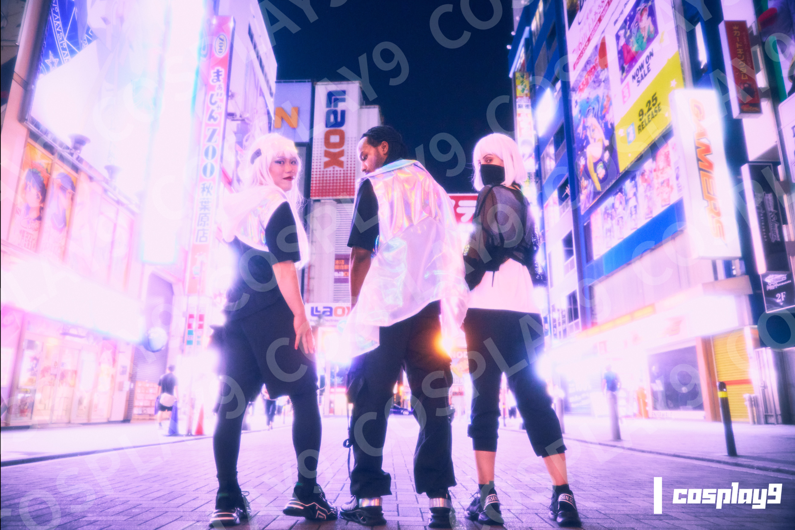 ネオン街でポーズをとるコスプレイヤーたち