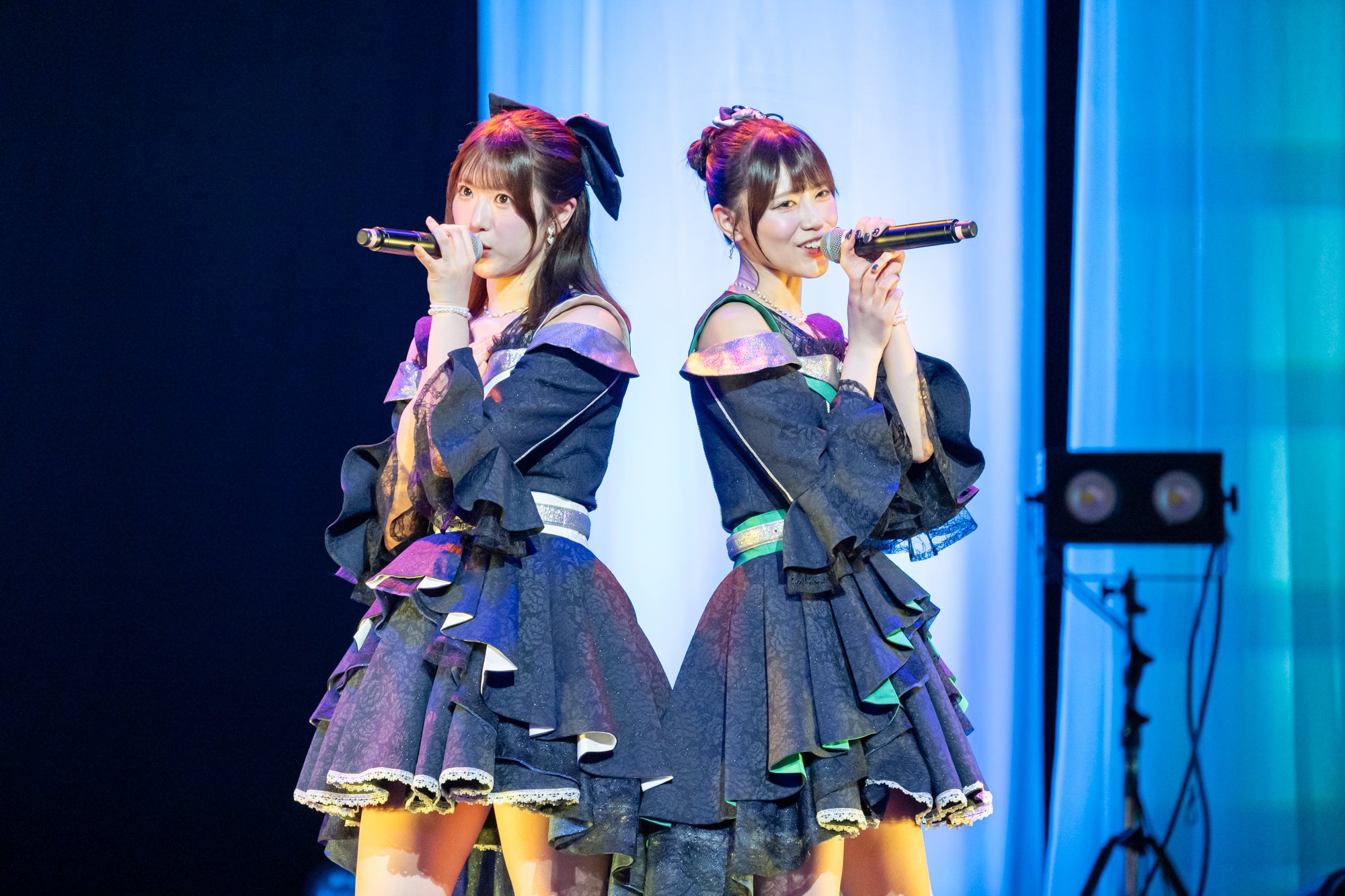 二人のメンバーがマイクで歌う