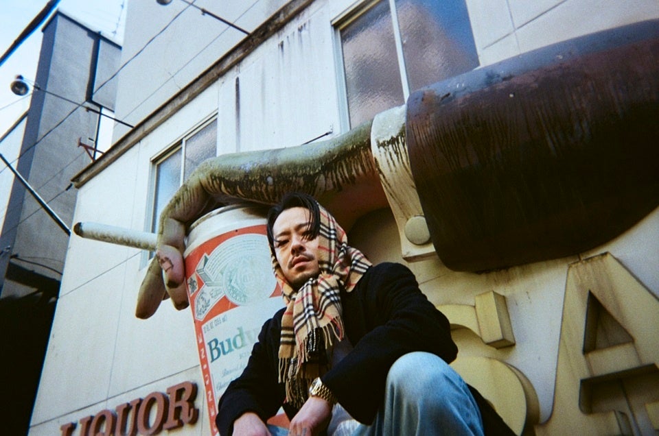 大きな看板の前で座る男性のポートレート