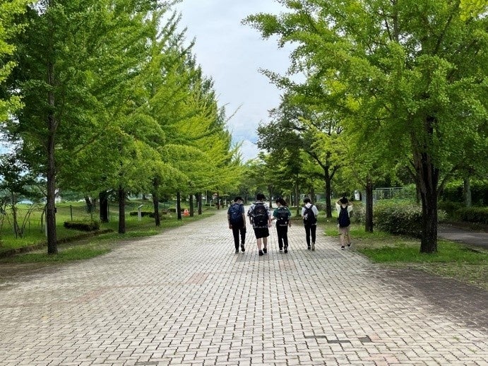 緑豊かな遊歩道を歩く学生たち