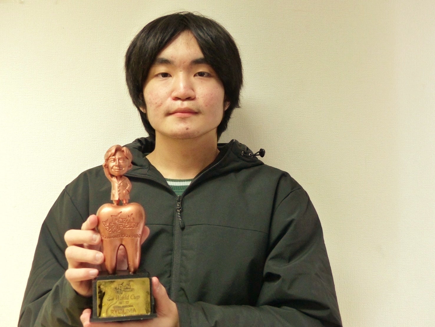 銅色のトロフィーを持つドローン選手