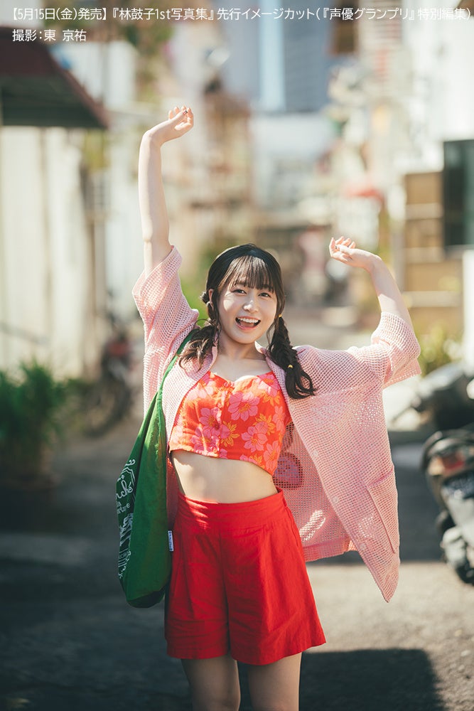 赤い服を着た女性が手を挙げて楽しそうに笑顔