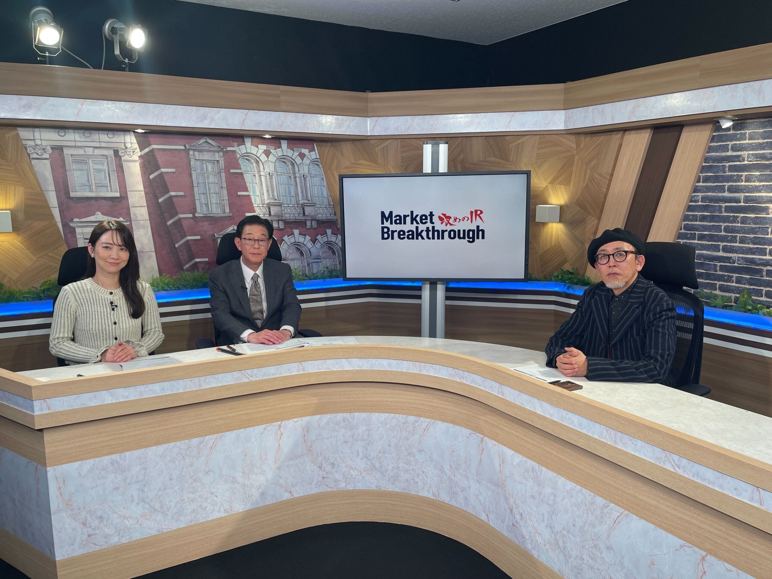 3人がテーブルで討論するスタジオシーン