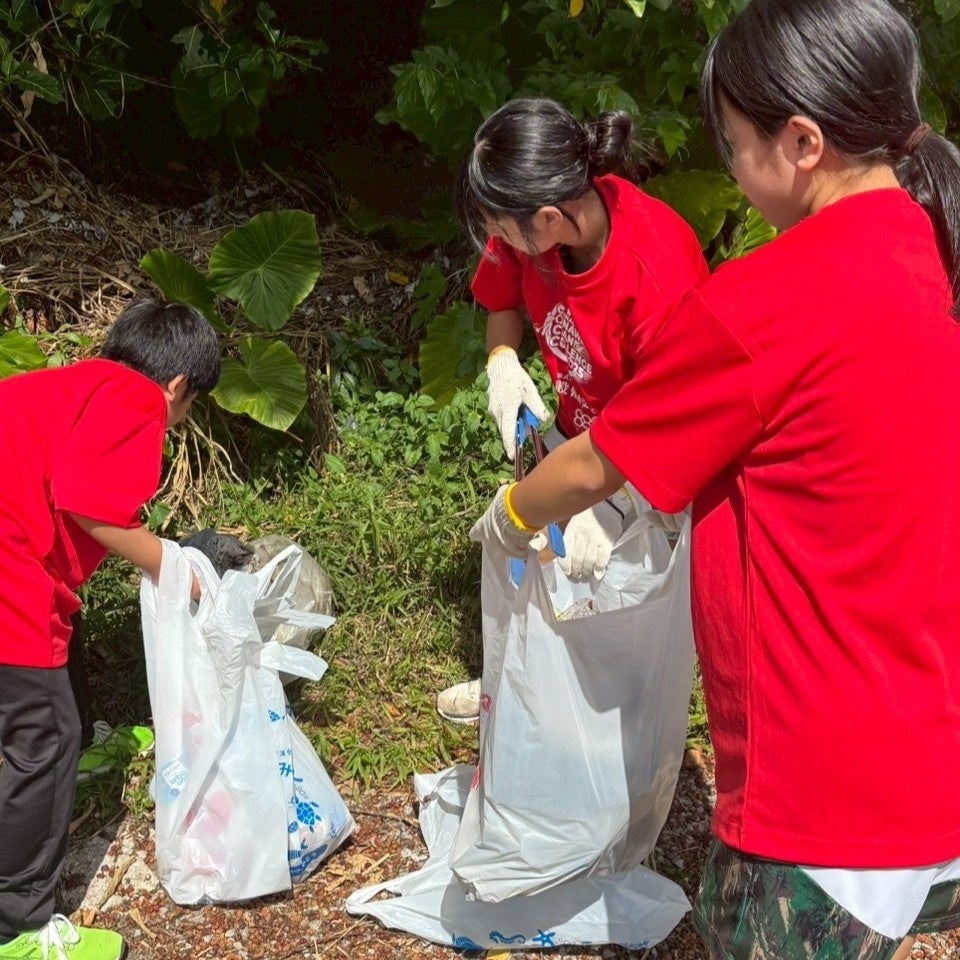 草むらでゴミを集める清掃ボランティア