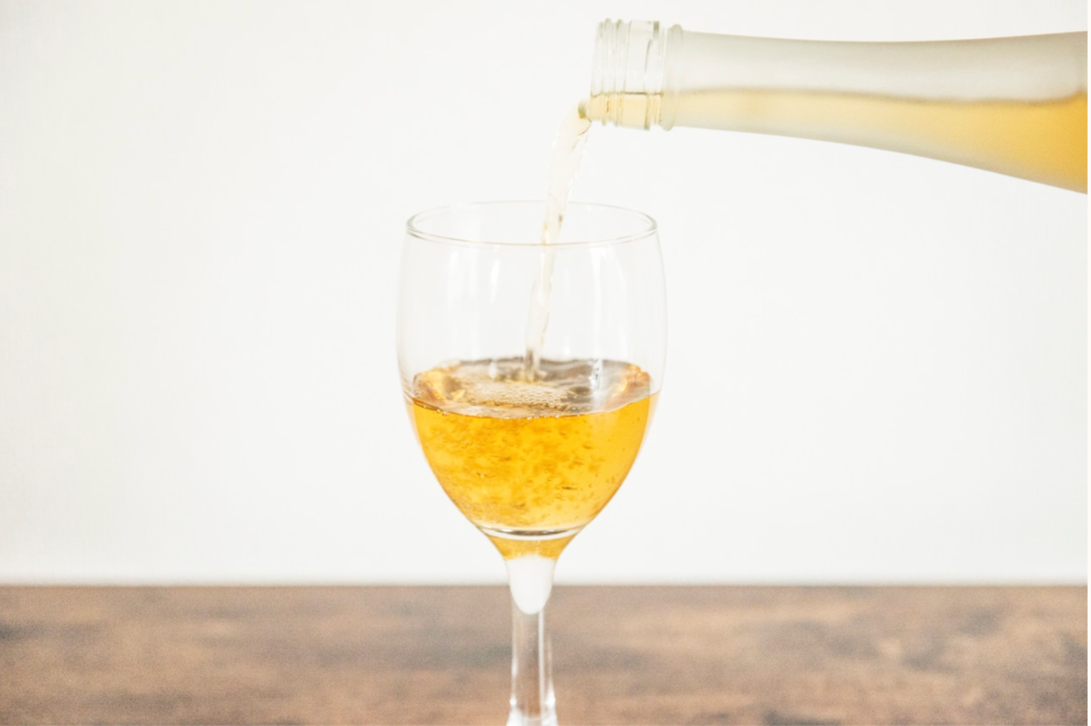 オリジナルラベルのお酒がグラスに注がれる様子