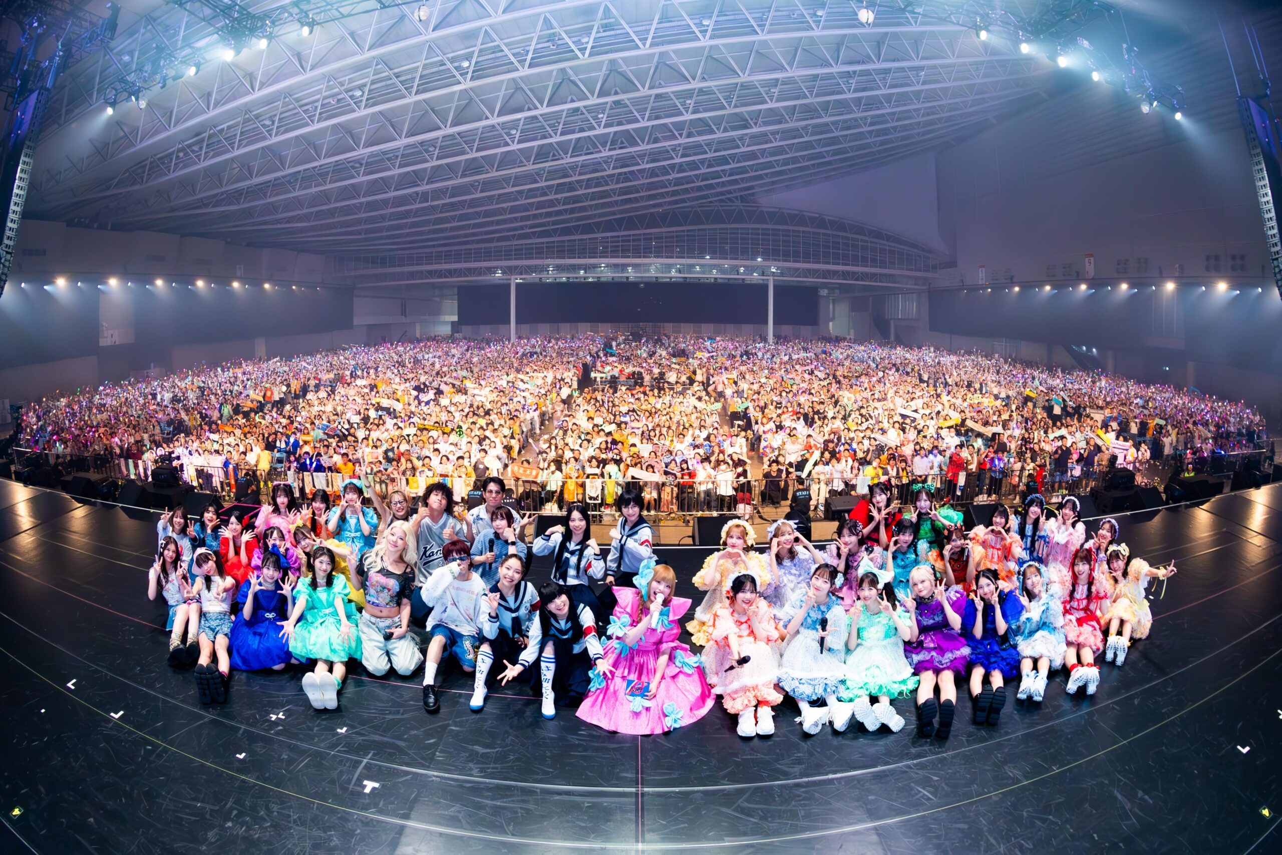 満員の観客とアイドルグループ