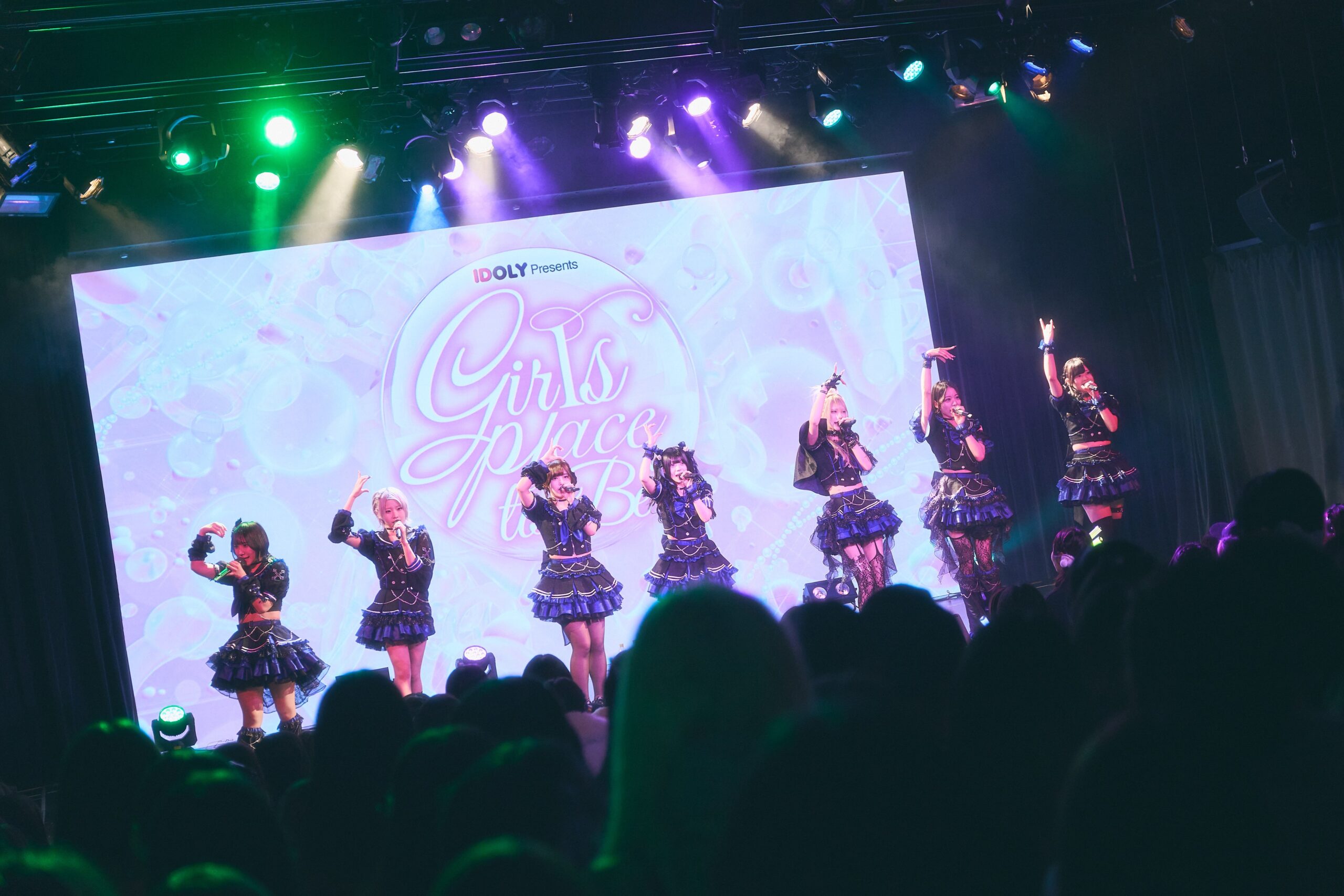 黒い衣装でダンスを披露するアイドルたち