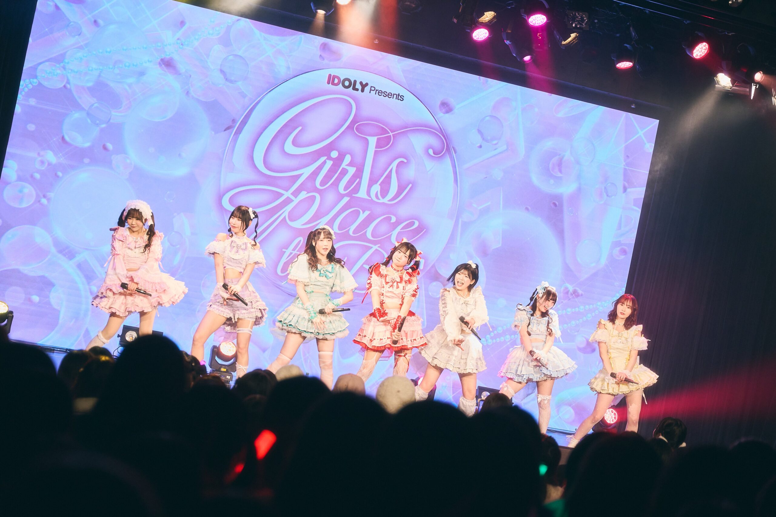 カラフルな衣装でステージに立つグループ