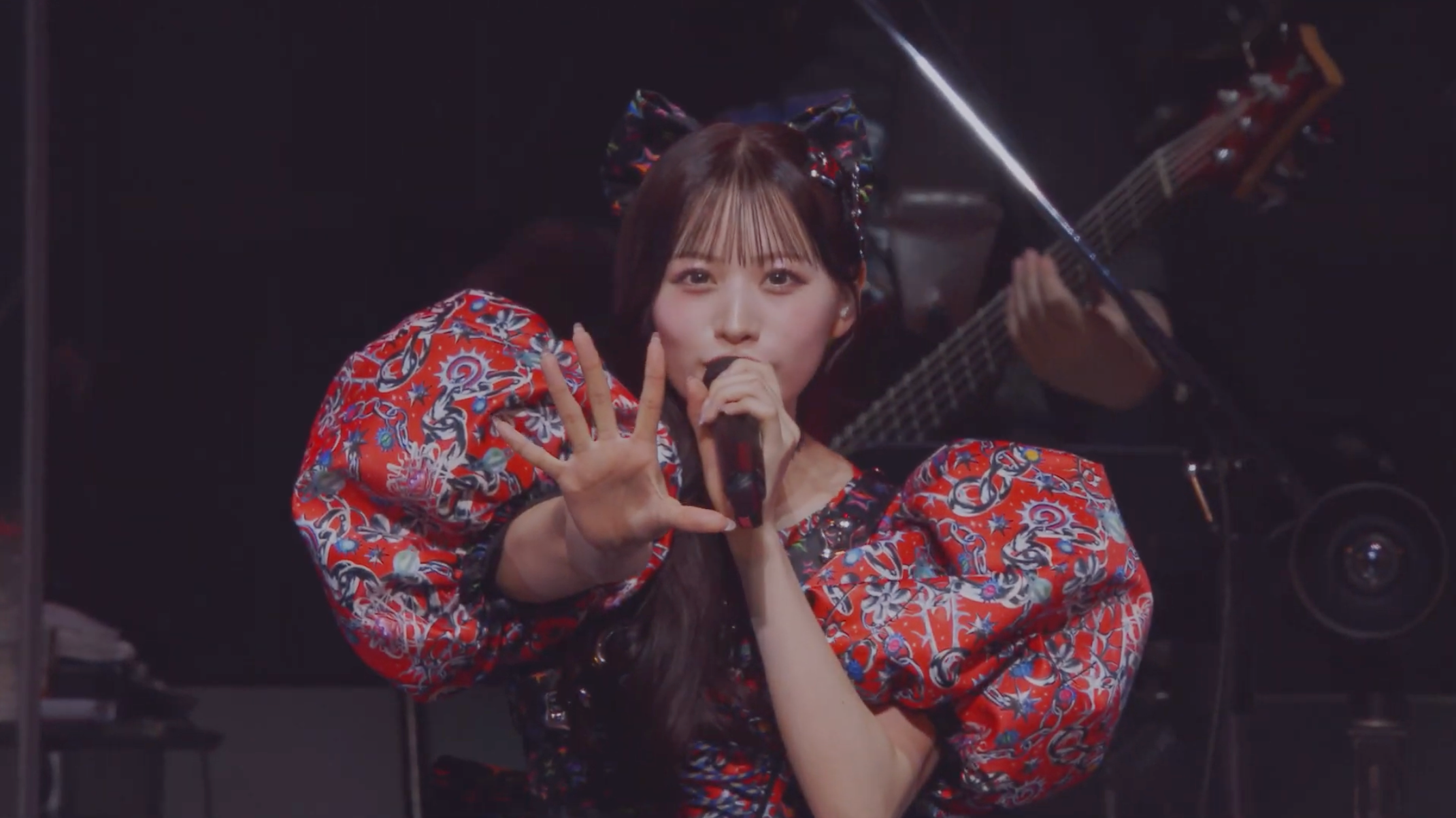 赤い衣装で歌うアイドルのパフォーマンス