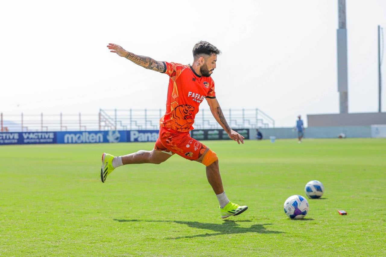 グラウンドでボールを蹴るサッカー選手