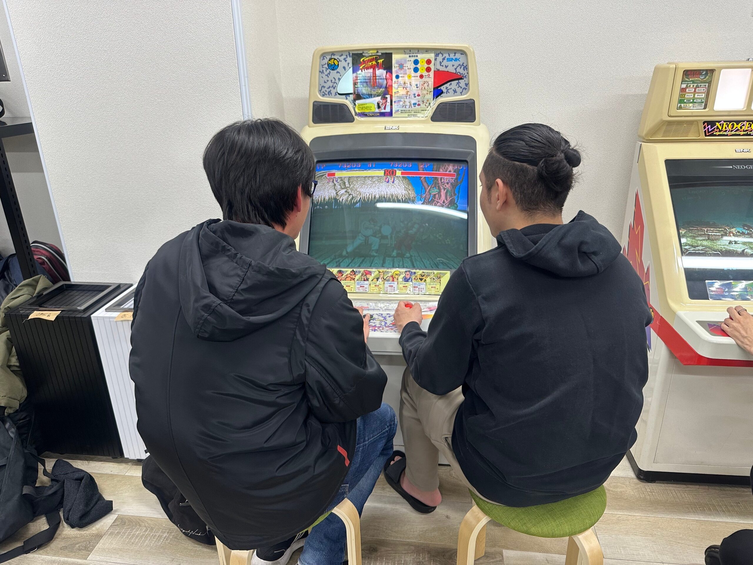 アーケードゲームを楽しむ二人の男性