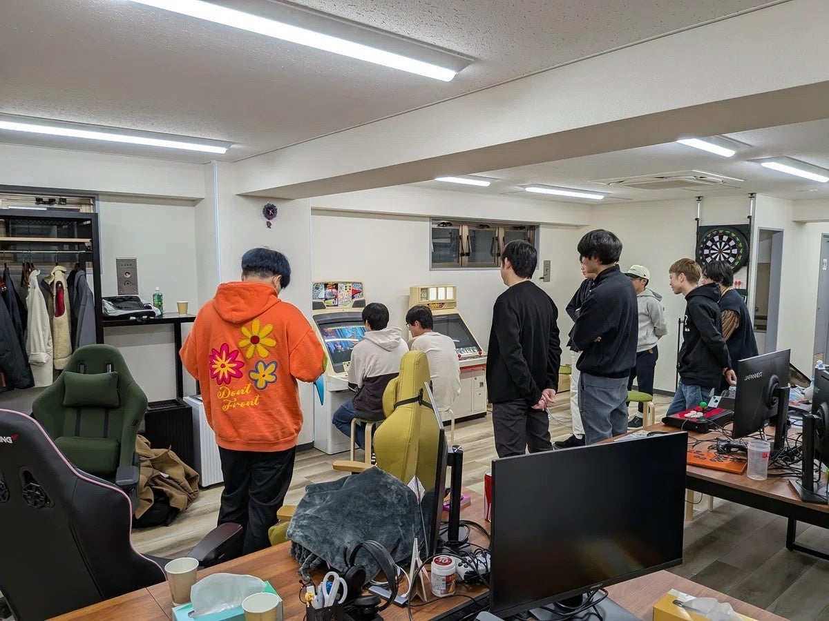 アーケードゲームを観戦する集団