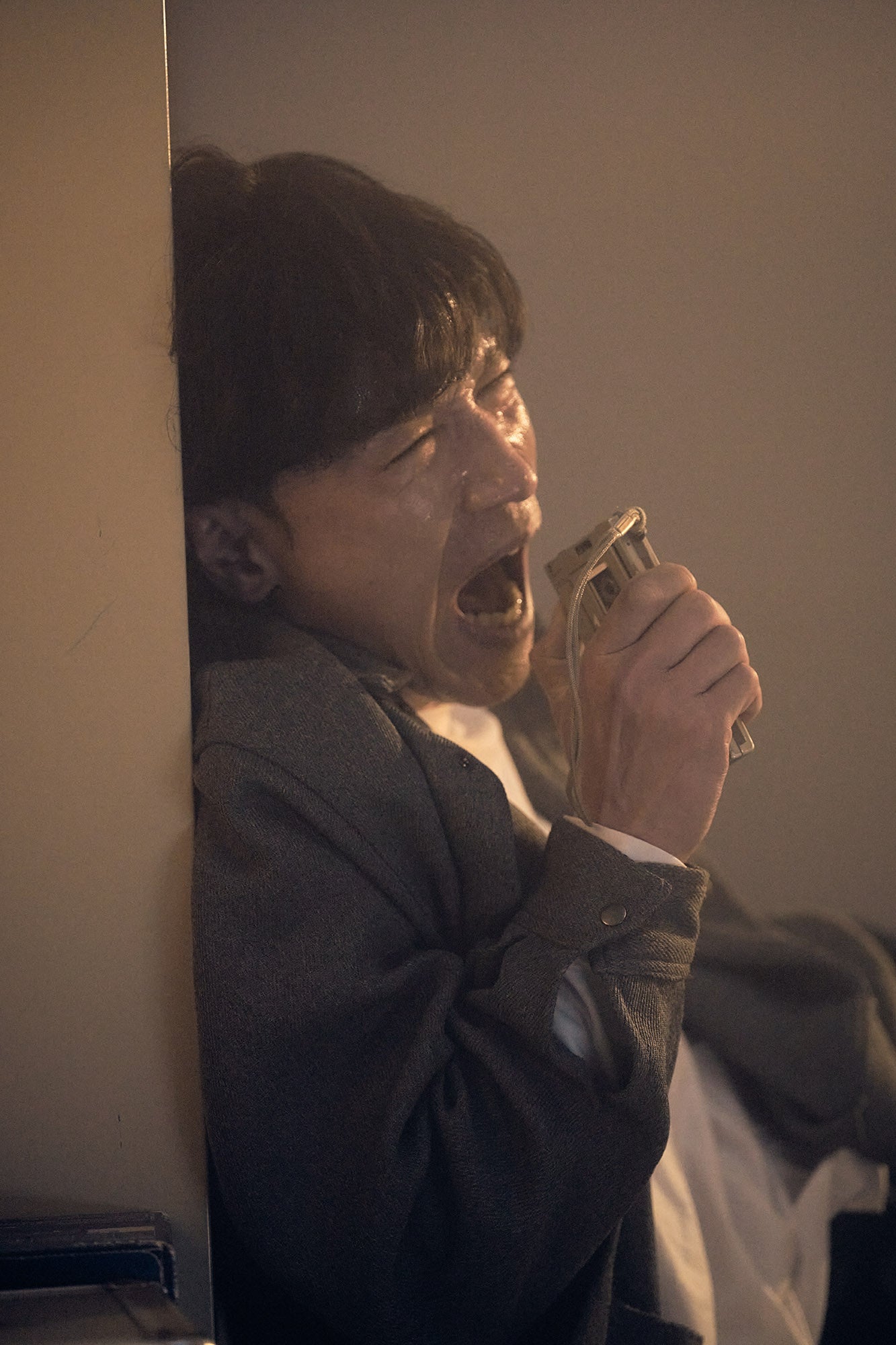 絶叫しながら壁にもたれる男性