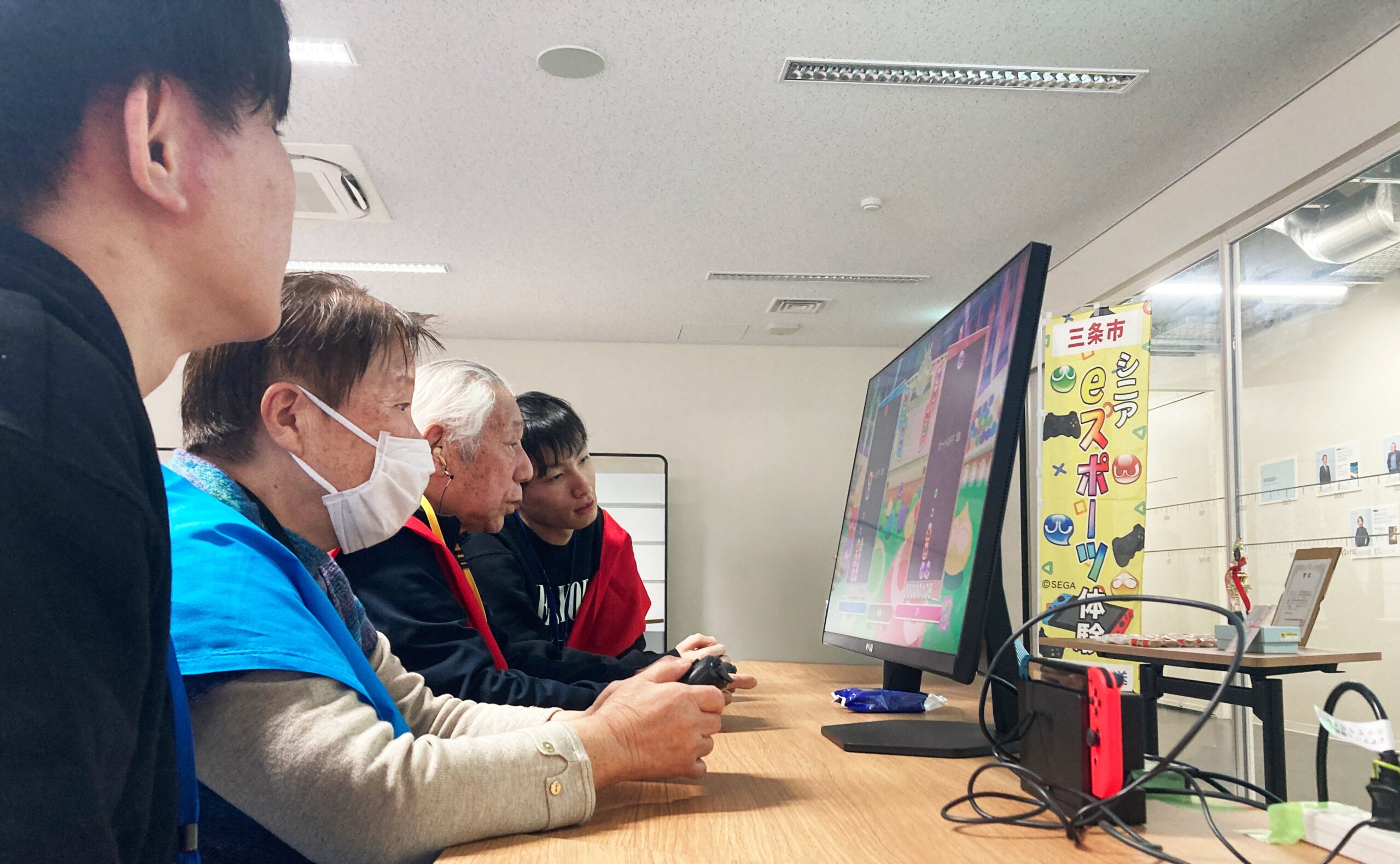 シニアと学生がテレビゲーム対戦