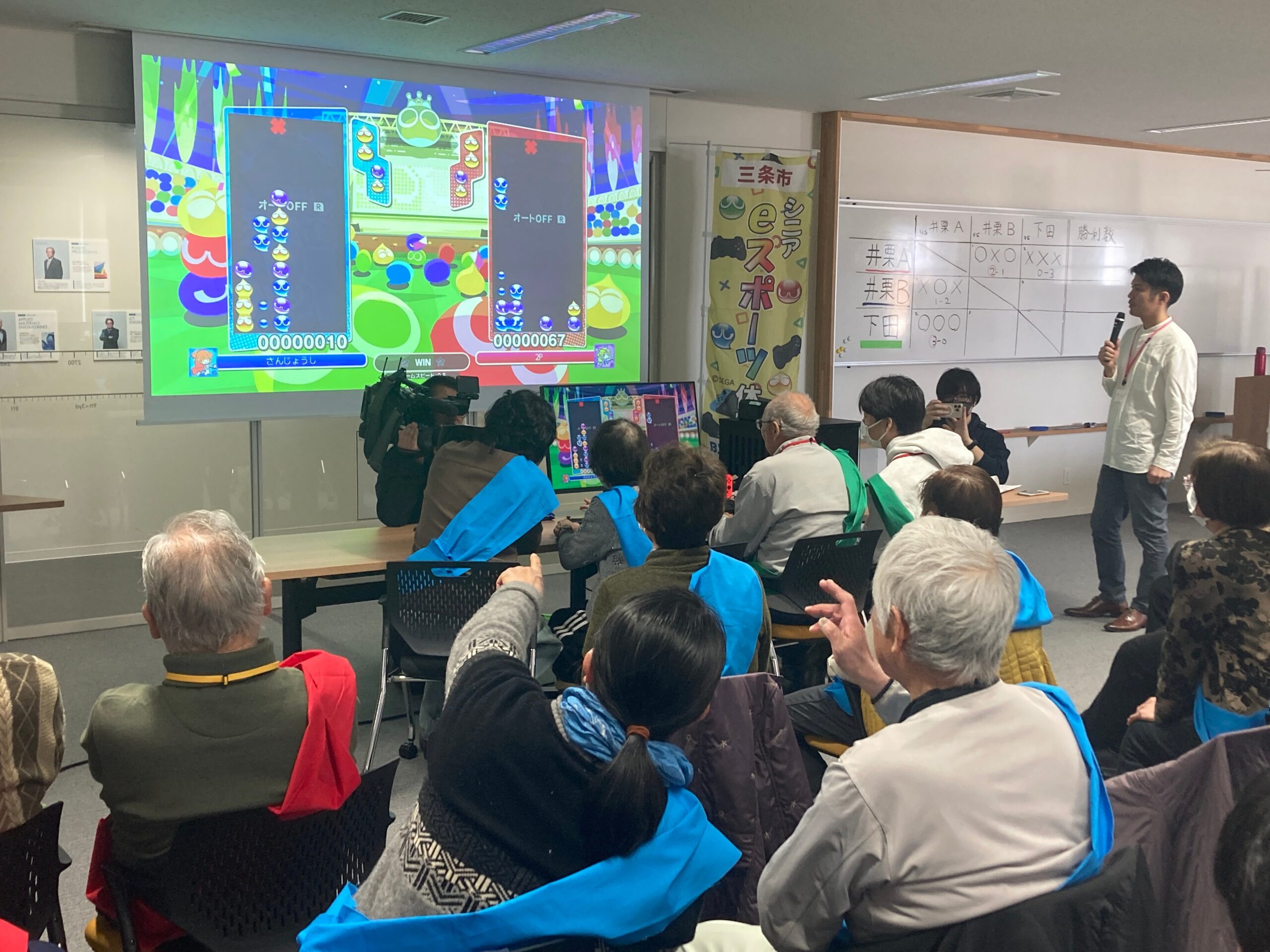 大画面でぷよぷよ大会を楽しむ参加者