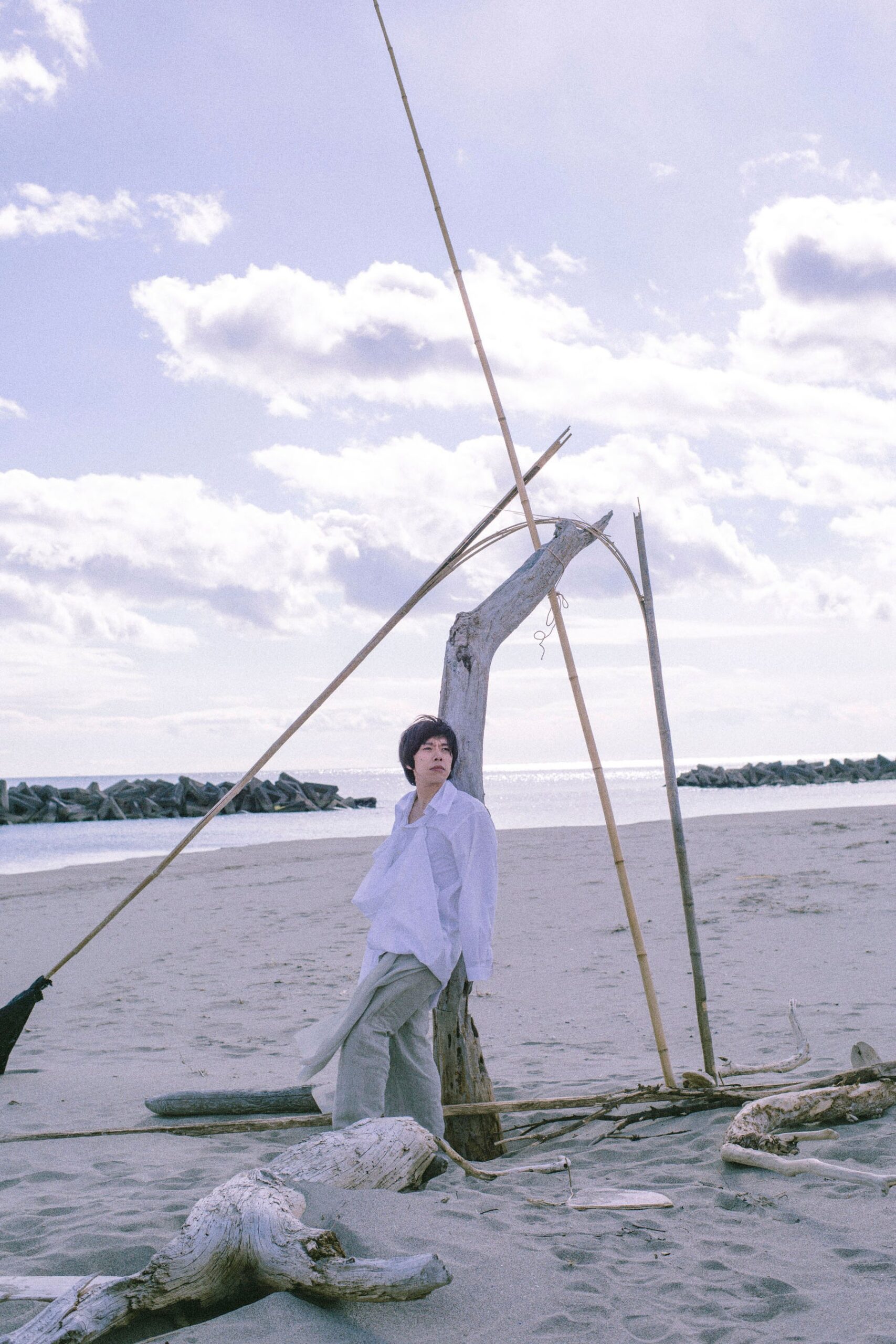 砂浜に立つ白いシャツ姿の人