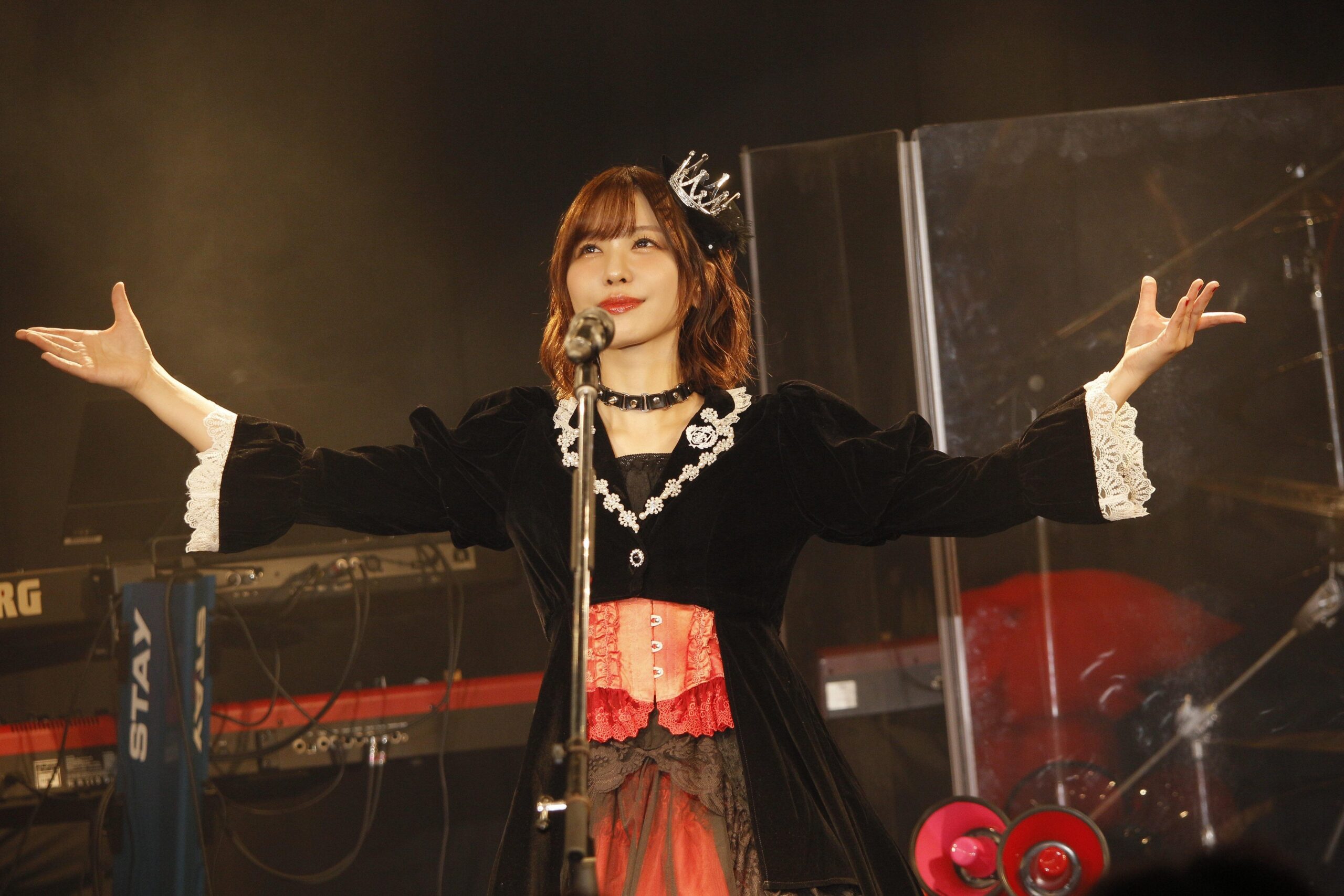 観客に向かって腕を広げる歌手