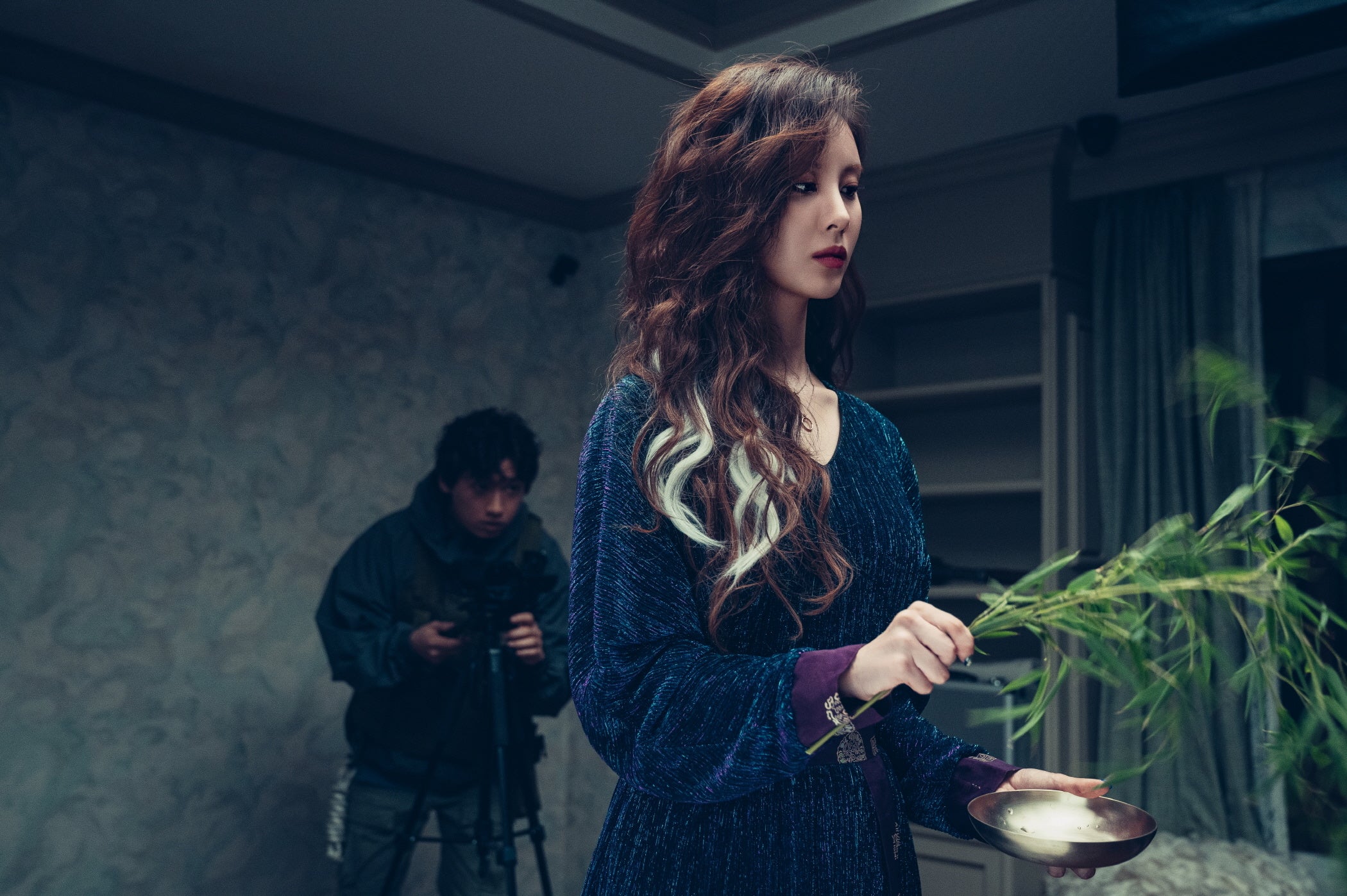 儀式を行う女性と調査員の場面