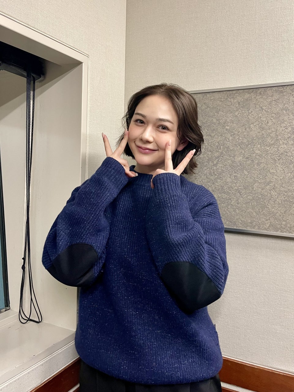 青いセーターのMINAMIさんが微笑む