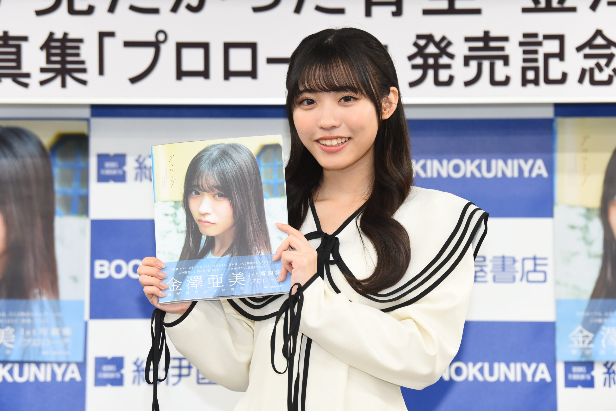 金澤亜美が写真集を手にし微笑む