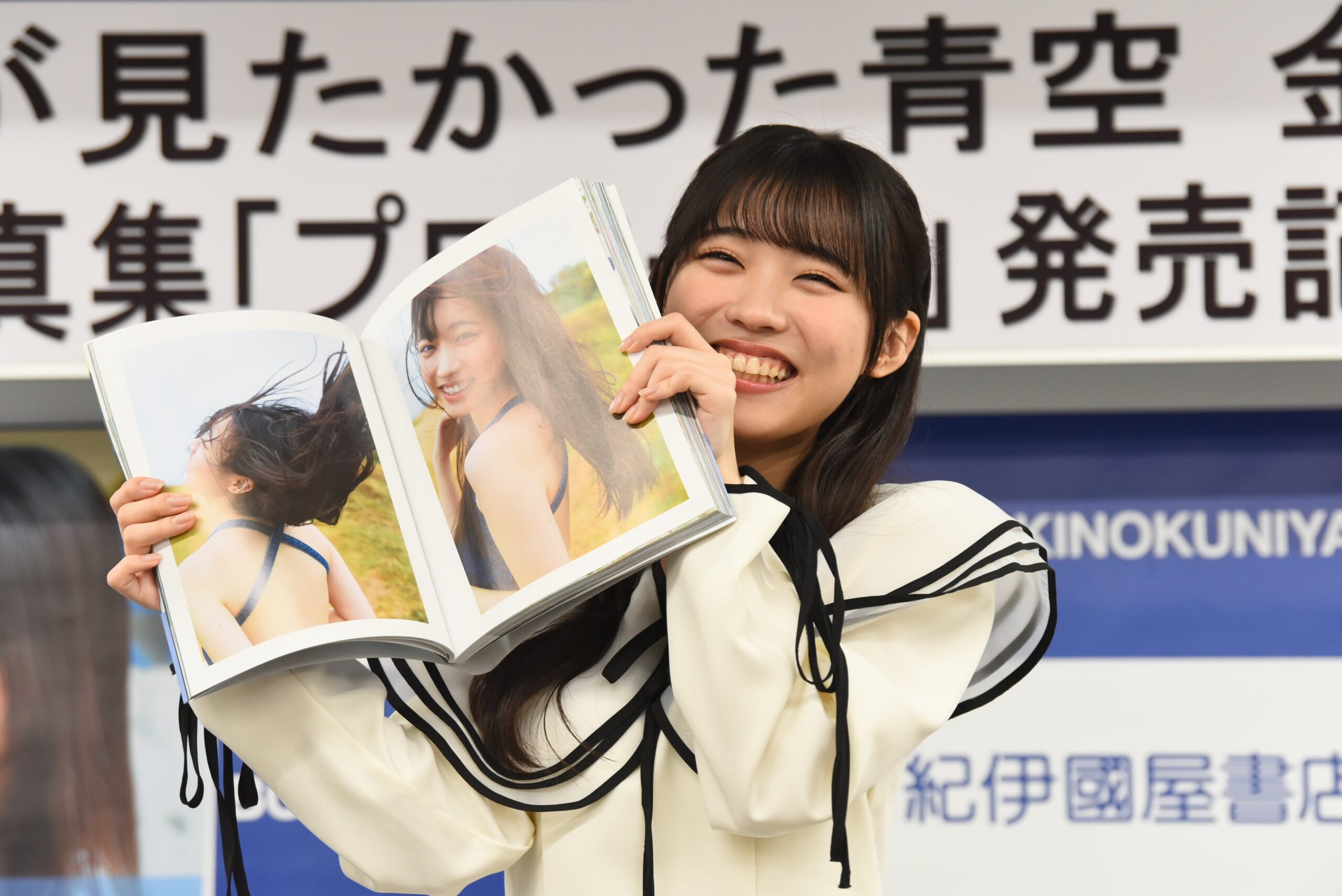 金澤亜美が笑顔で写真集を掲げる