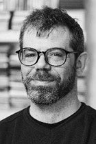 シェルフ前に立つ眼鏡の男性