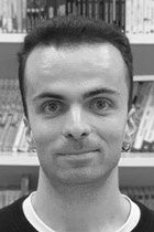 棚の前で微笑む若い男性