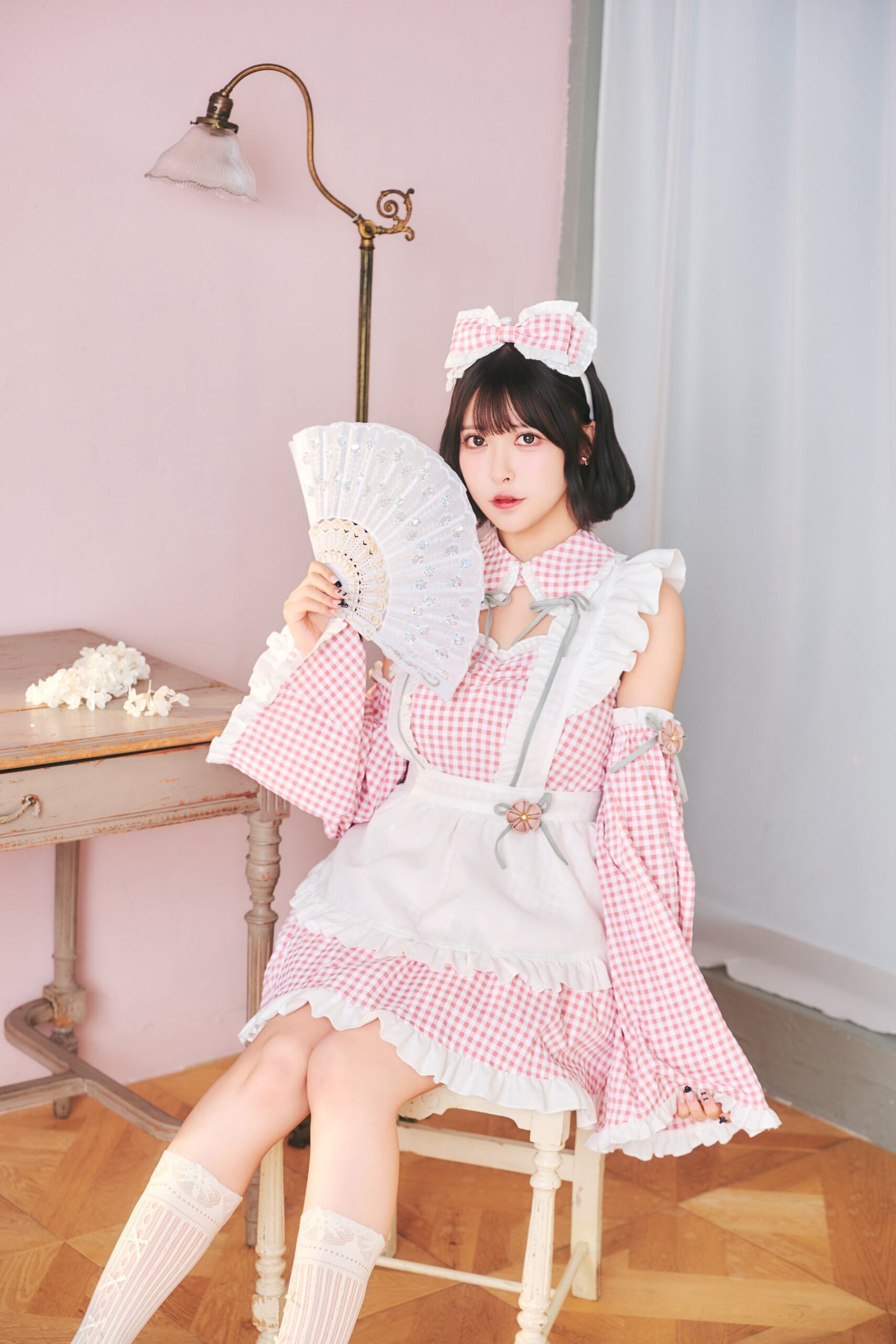 椅子に座るピンクのメイド姿の女性