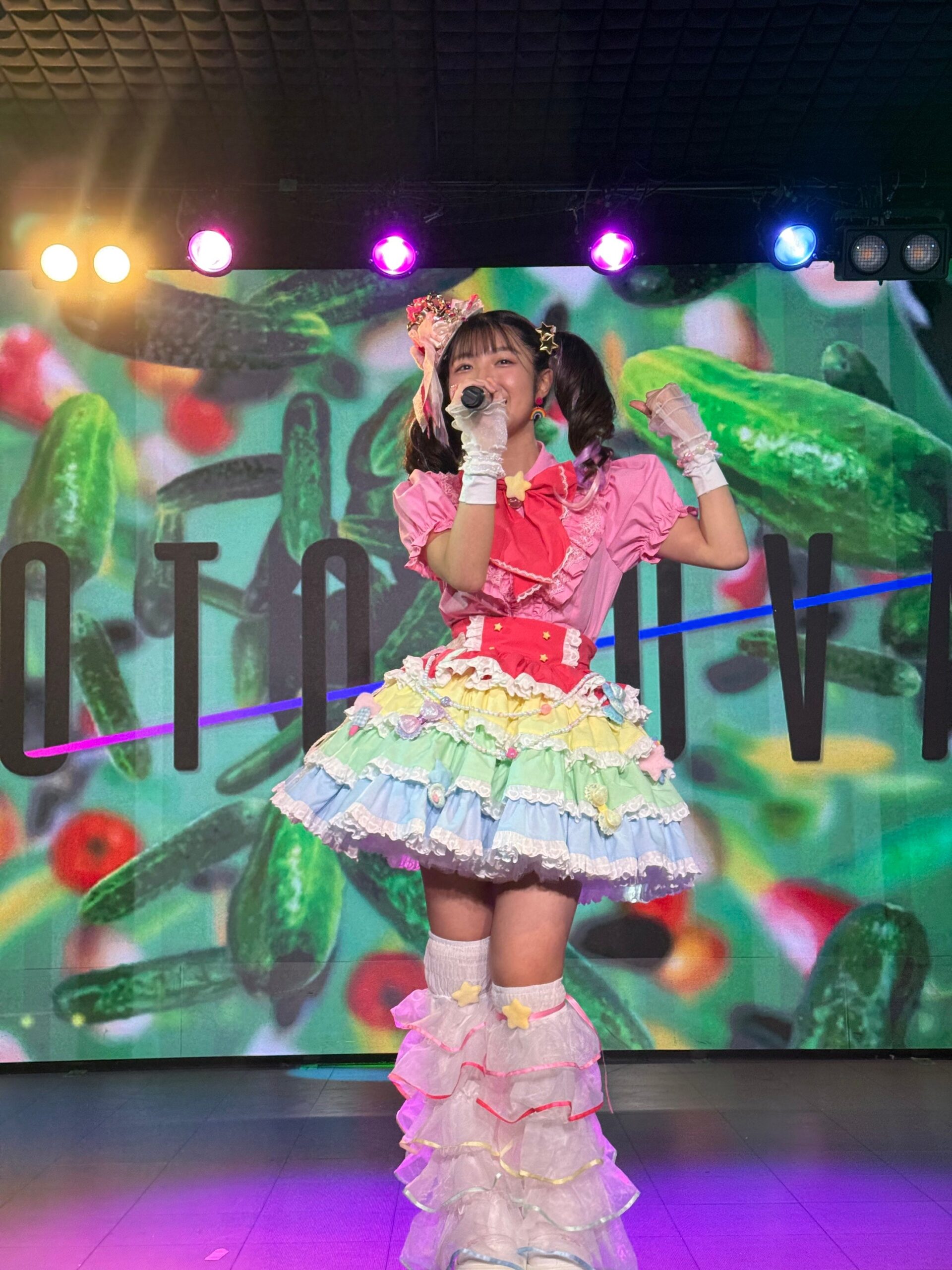 ステージで歌うアイドルと鮮やかな背景