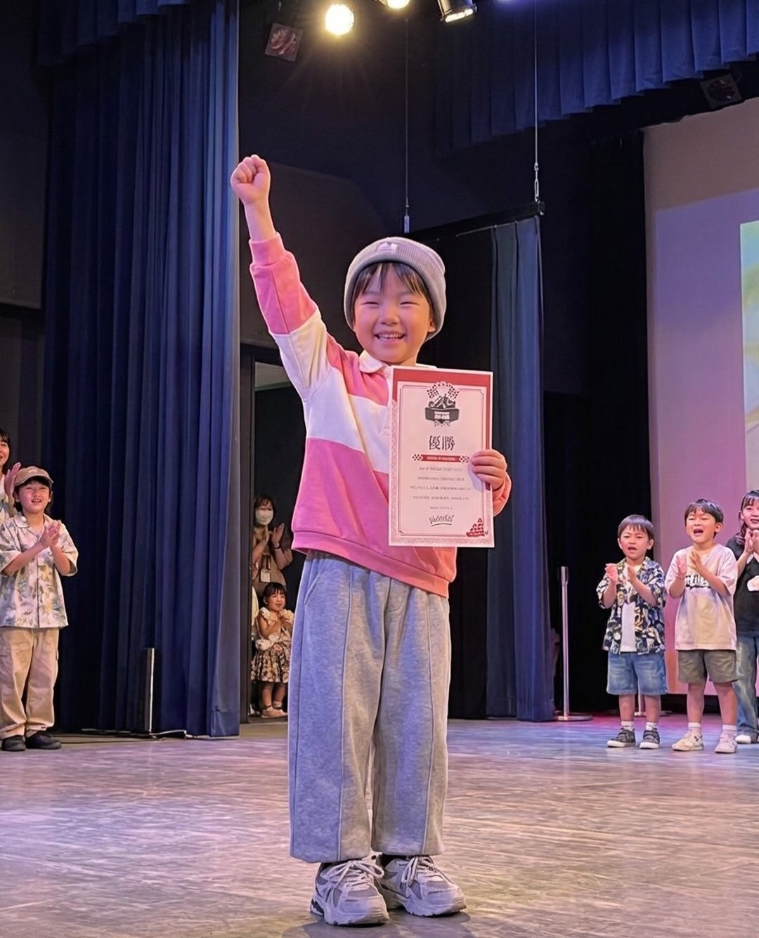 優勝証を持ち上げる少年