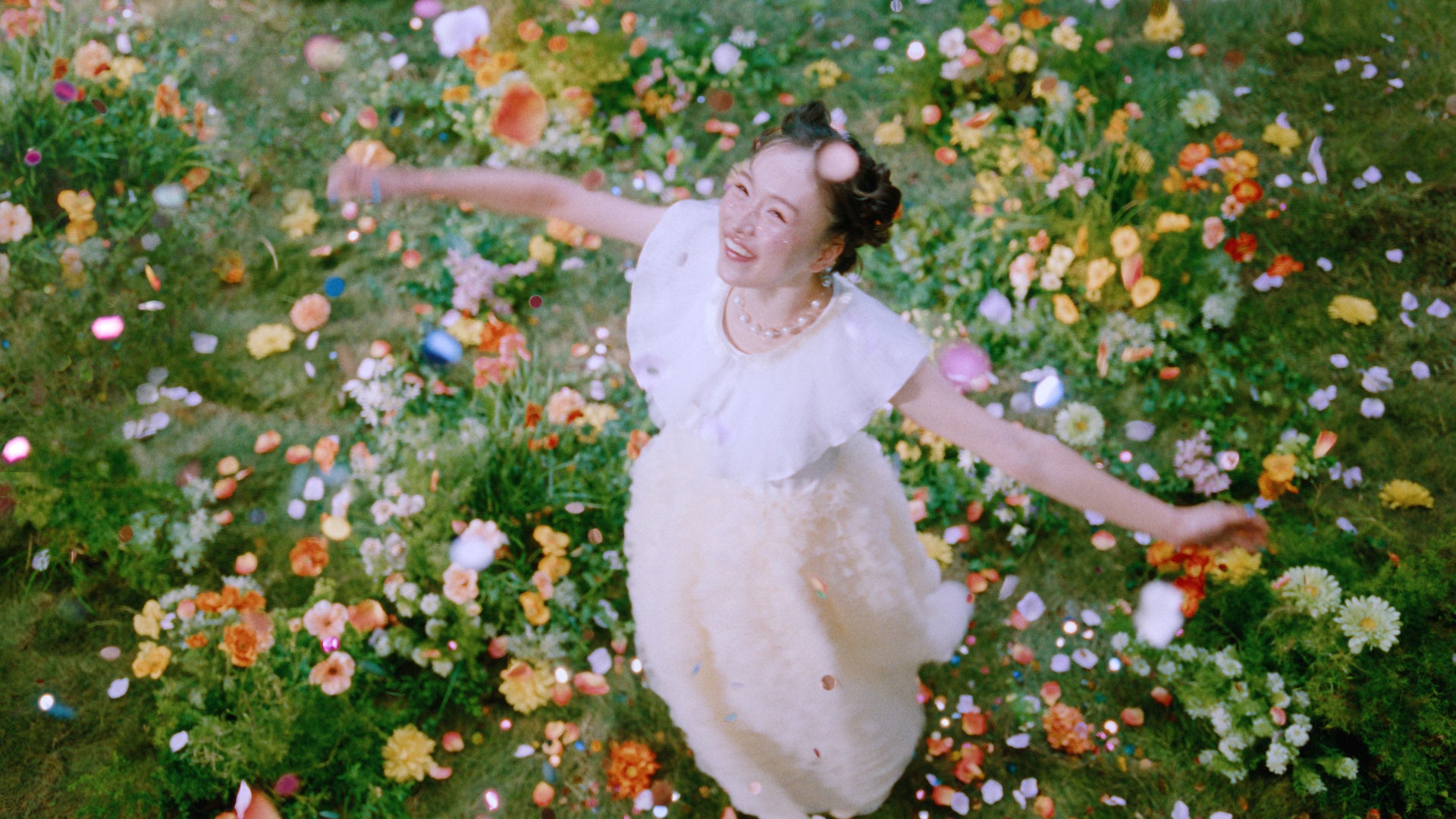 花に囲まれたドレス姿の女性が笑顔