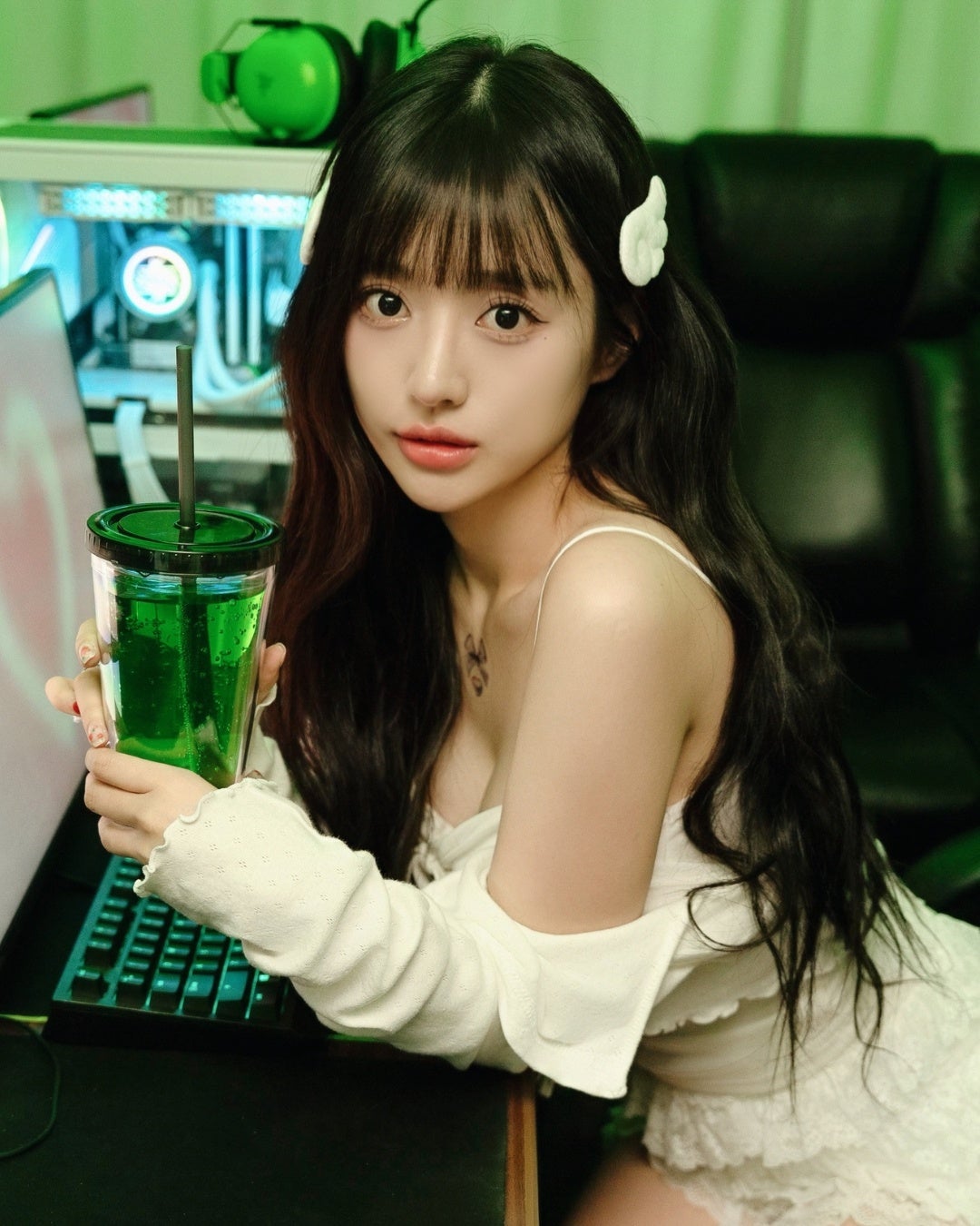 緑のドリンクを持つゲーマースタイルの女性