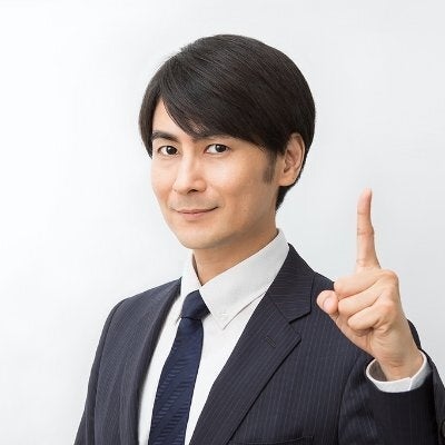 スーツ姿で指を立てる男性