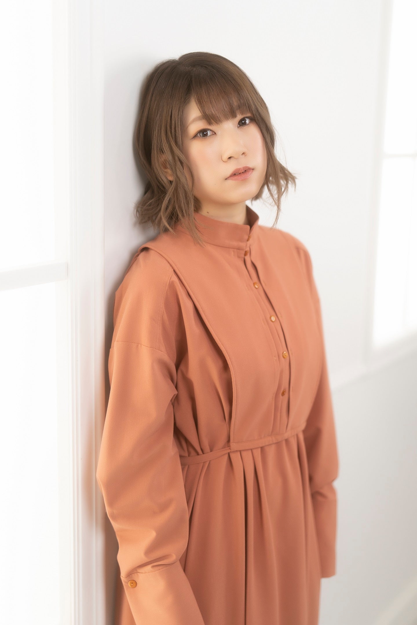 壁にもたれる若い女性