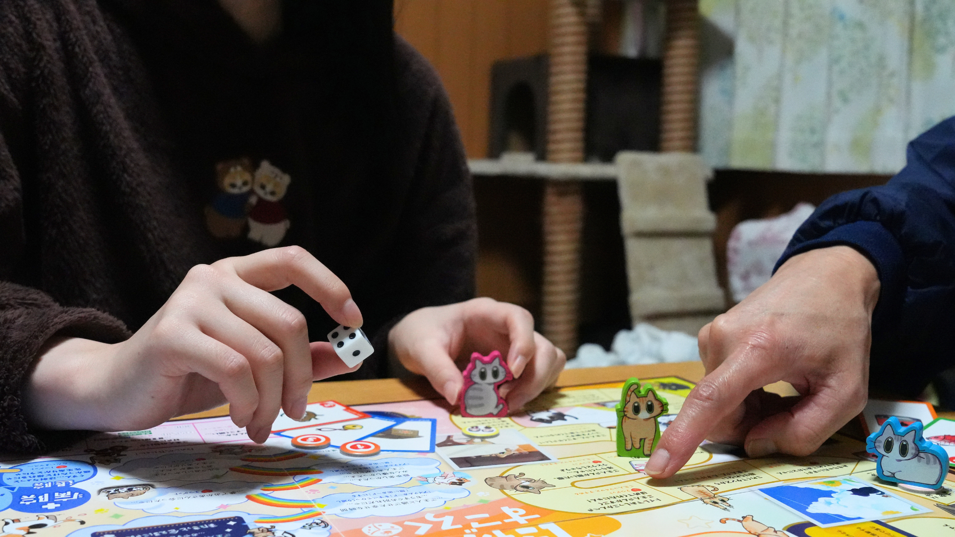 にゃん生すごろくをプレイする人々の手元