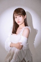 白い服の女性が照明の下でポーズ