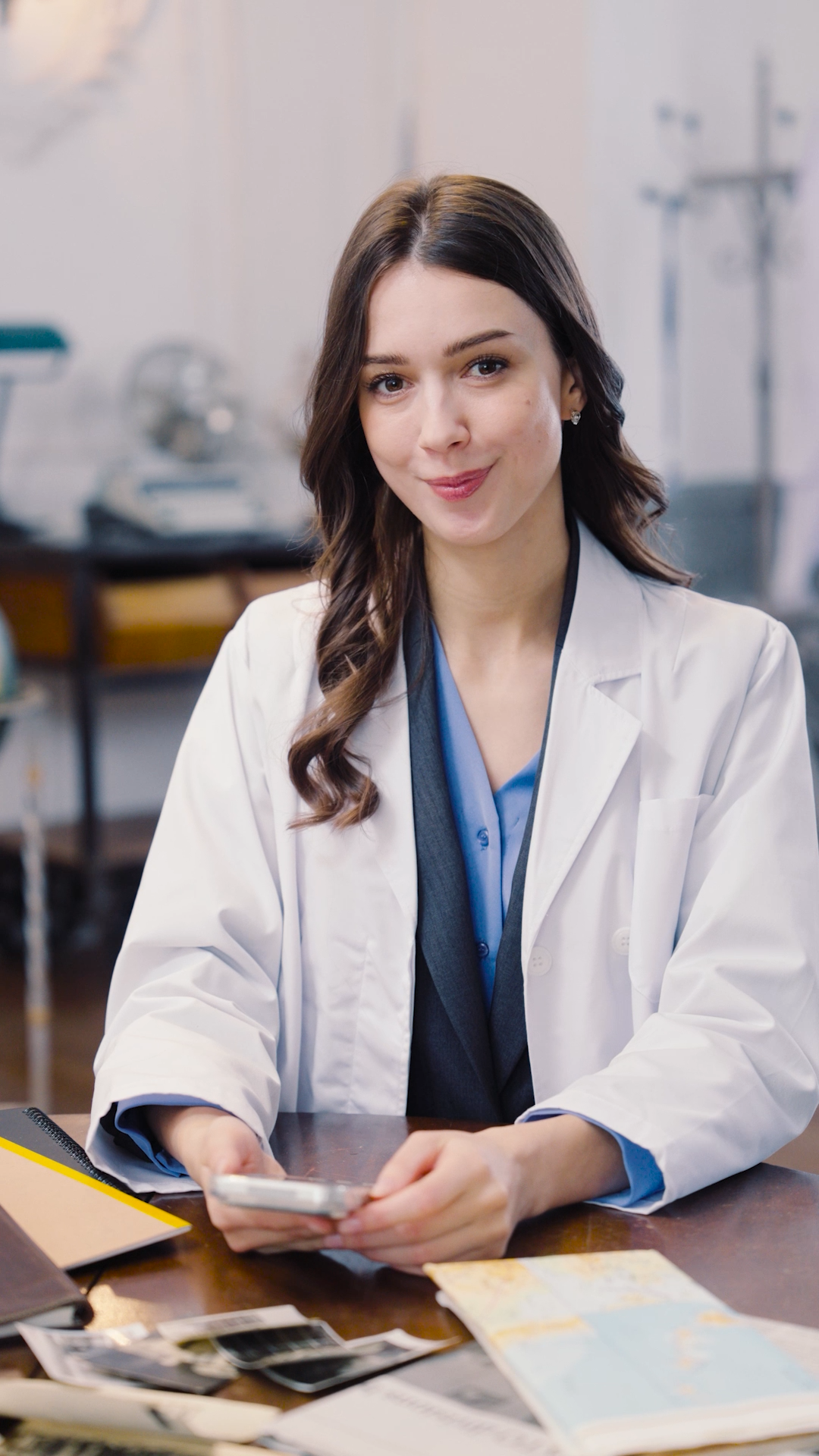 白衣の女性が笑顔で座る医療機関風