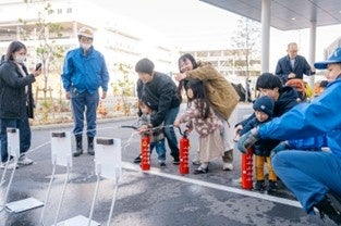 消火訓練を行う親子とスタッフ