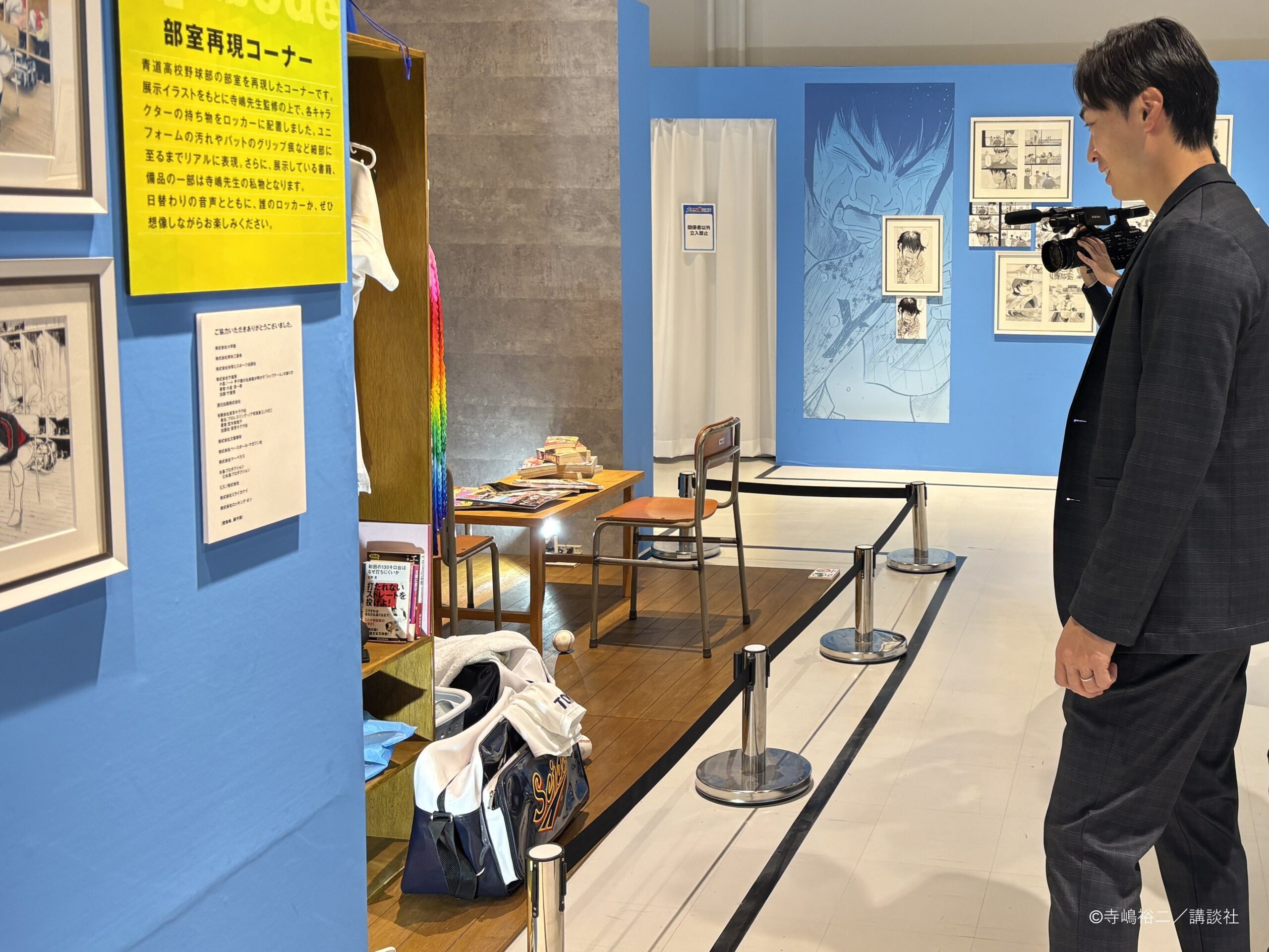 部室再現コーナーを見学する男性